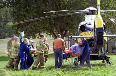 
Medical personnel take a 61-year-old man to a waiting MedStar helicopter after he was thrown from his horse Wednesday. The man, who suffered a head injury, was riding his horse on Valley Chapel Road when a passing truck spooked the animal. The horse fled the scene, and is unharmed. The man is in critical condition.
 (Colin Mulvany / The Spokesman-Review)