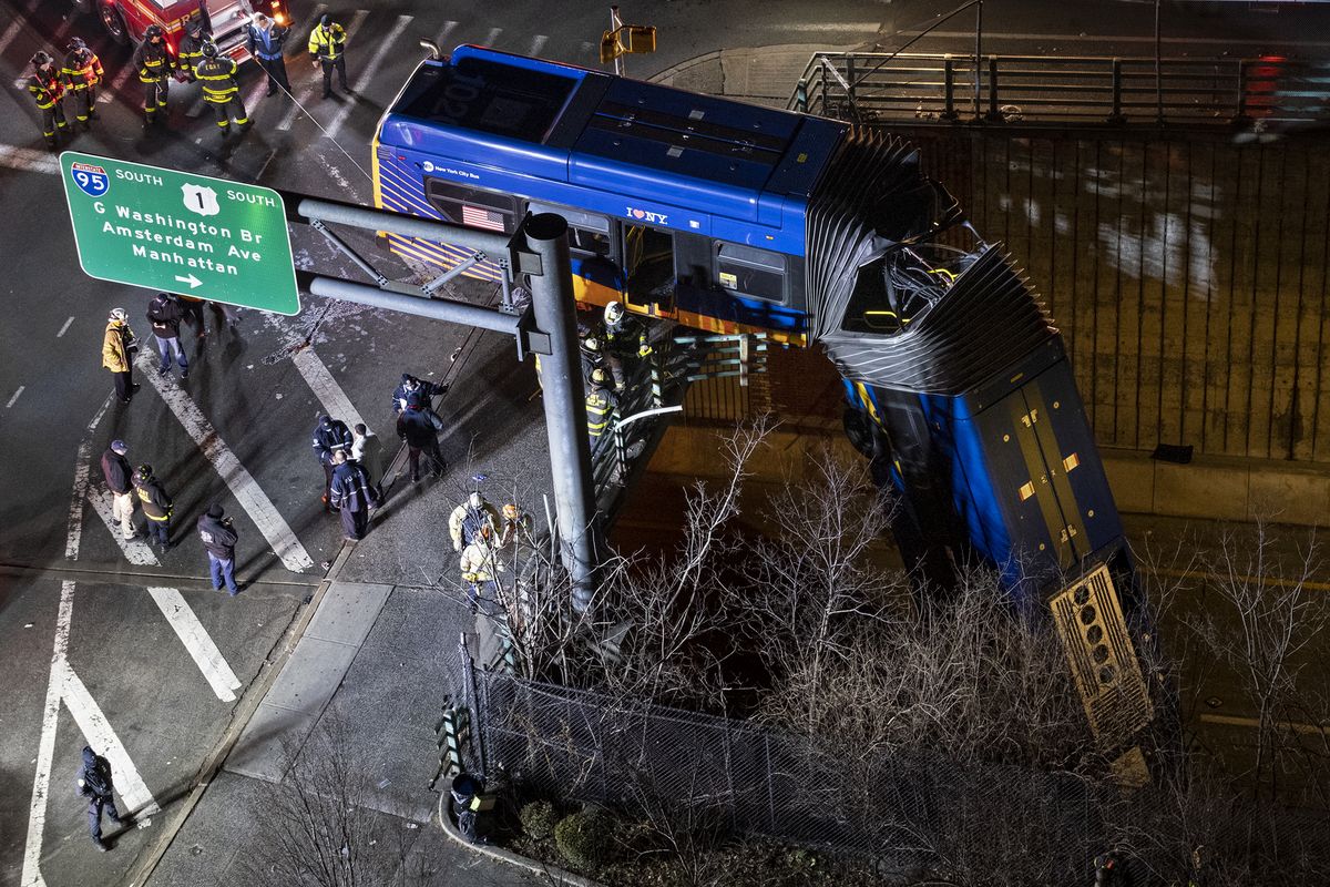 A bus in New York City which careened off a road in the Bronx neighborhood of New York is left dangling from an overpass Friday, Jan. 15, 2021, after a crash late Thursday that left the driver in serious condition, police said.  (Craig Ruttle)
