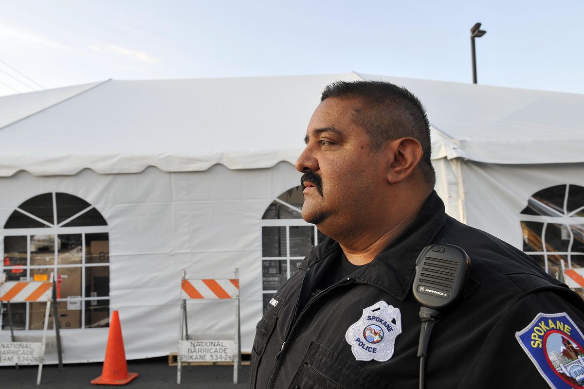 FILE – John Arredondo, a veteran officer of the Spokane Police Department, watches over a tent full of flatscreen televisions set up for a sale at the north Spokane Huppin’s store on Sept. 15, 2011. (Jesse Tinsley / The Spokesman-Review)
