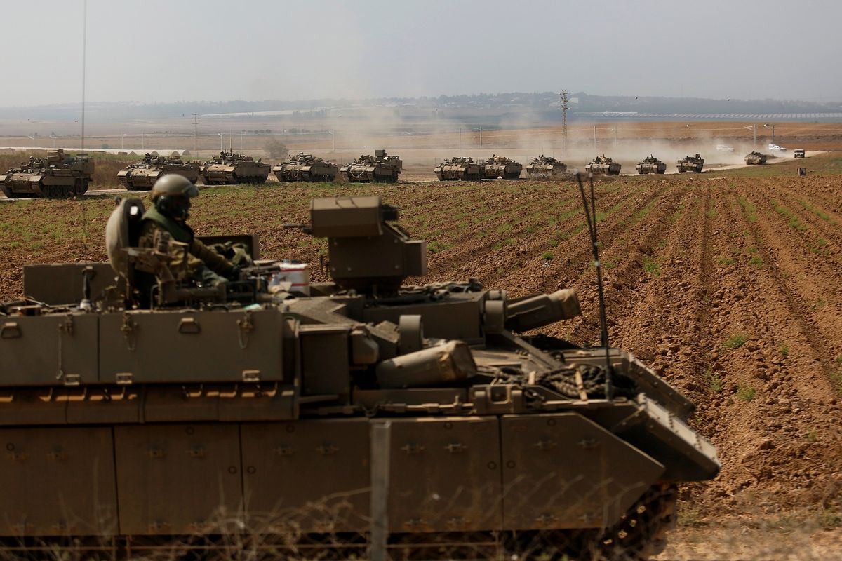 Above: Tanks move in formation near the border with Gaza on Saturday near Sderot, Israel. Left: Palestinian citizens fill water from water stations in the street in Khan Younis, south of Gaza City, Gaza, on Sunday. Residents suffer from water and electricity outages due to Israeli raids on the city.  (Amir Levy)