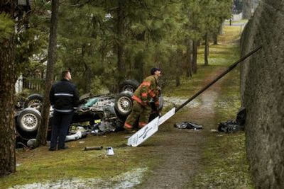 
Firefighters survey the scene of a car accident off of Mill Road, near Hastings Road, on Friday. Gerhard Muelheims, 41, was driving his 13-year-old son to basketball practice at St. George's when the car lost traction and slid  over the embankment. 
 (Kathryn Stevens / The Spokesman-Review)