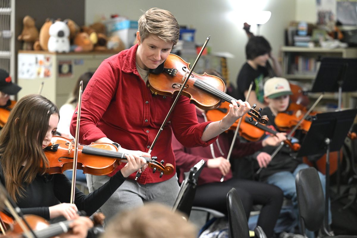 Orchestra teacher Jerilynn Harris picks up a violin to help students through a piece of music in class Tuesday in Spokane. Harris directs the orchestra in the Odyssey program at Libby Center. (Jesse Tinsley/THE SPOKESMAN-REVIEW)