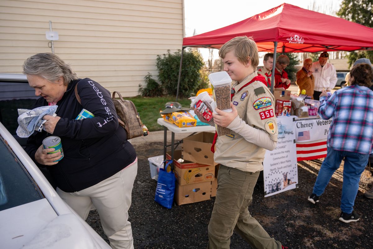 Boy Scout Alex Hunt with Troop 356 helps Melissa Estrada carry cat food to her car during Golden Wings Mobile Pet Food Pantry distribution day in Spangle on Nov. 20. The pet food pantry distributes pet food, toys, leashes and supplies monthly in Spangle, Rosalia and Malden – often in conjunction with a local food bank.  (COLIN MULVANY/THE SPOKESMAN-REVIEW)