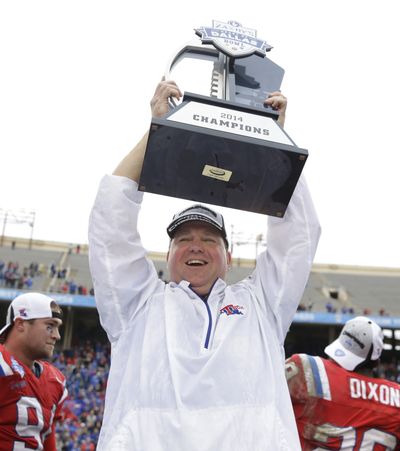 Louisiana Tech head coach Skip Holtz holds up the Heart of Dallas Bowl trophy after Bulldogs’ victory. (Associated Press)