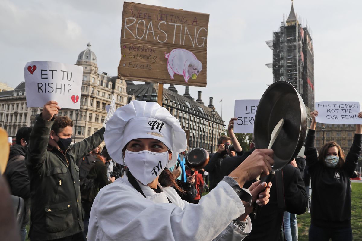 Hospitality workers protest in Parliament Square in London, Monday, Oct. 19, 2020. Hospitality workers are demonstrating outside Parliament against tougher coronavirus restrictions and the amount of financial support given by the government to the industry.  (Frank Augstein)