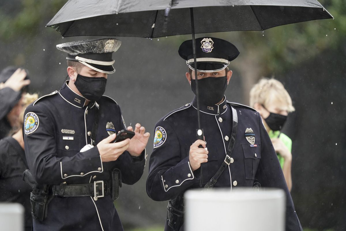 Members of the Delray Beach Police force arrive in the rain for a memorial service for FBI Special Agent Laura Schwartzenberger, Saturday, Feb. 6, 2021, in Miami Gardens, Fla. Schwartzenberger and Special Agent Daniel Alfin were killed while serving a warrant this week in Sunrise, Fla.  (Hans Deryk)