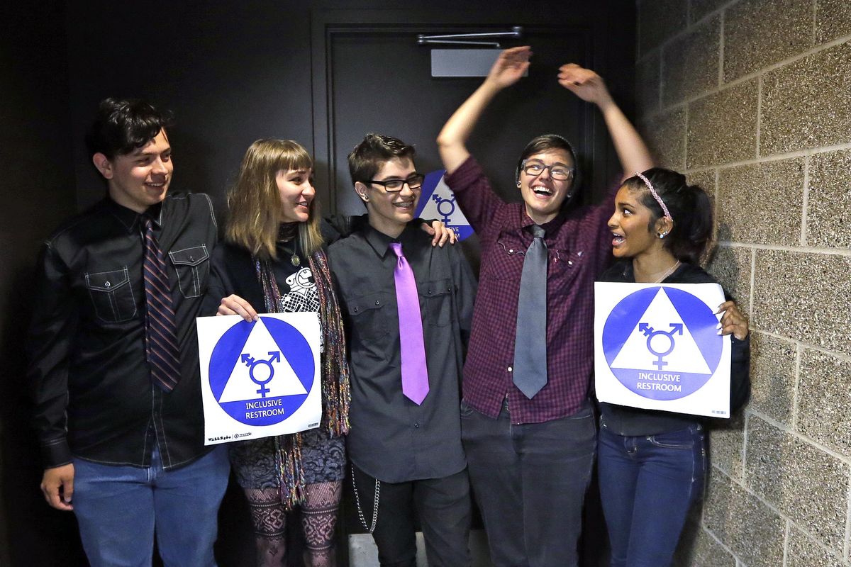 Destin Cramer, second right, embraces friends from the school’s Gender Awareness Group as they pose for a photo at the opening of a gender-neutral bathroom at Nathan Hale high school Tuesday, May 17, 2016, in Seattle. From left are Jakob Ainsworth, Honour Beattie, Zack Bebout, Cramer and Deena Kennedy. (Elaine Thompson / AP)