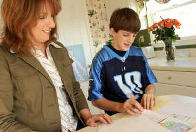 
Susan Cole goes over  homework with her 12-year-old son Danny at their Mt. Airy, Md., home recently. The Coles ran into difficulties at a local airport when they were told by a Southwest Airlines ticket agent that Danny Cole would be treated as an adult and not given any special attention during a flight by himself to Texas. Associated Press
 (Associated Press / The Spokesman-Review)