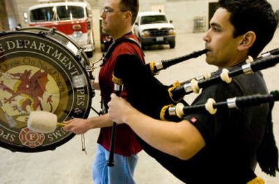
Brian Foster-Dow, left, and Kurt Kilayko practice a song on their bagpipes for Saturday's St. Patrick's Day Parade in downtown Spokane, at a fire warehouse facility near Spokane Fire Station 8. Foster-Dow and Kilayko are members of the Spokane Valley Fire Department Pipes and Drums Corps. 
 (Kathryn Stevens / The Spokesman-Review)