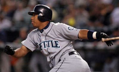 
Seattle's Jose Lopez drives in Adrian Beltre on a first-inning single off Enrique Gonzalez. 
 (Associated Press / The Spokesman-Review)