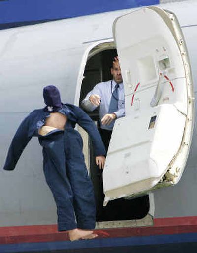 
A dummy signifying an executed hostage is thrown from a plane during a terrorism drill  at Logan International Airport in Boston on Saturday. 
 (Associated Press / The Spokesman-Review)