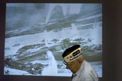 
Pearl Harbor survivor Warren Schott pauses to gather his thoughts as he stands in front of a projected image of Pearl Harbor shot from a Japanese plane Dec. 7, 1941.
 (Photosby Christopher Anderson / The Spokesman-Review)