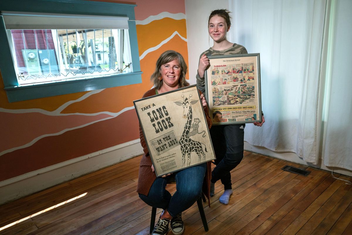Molly McCahon and her daughter, Juliet Jennings, 12, hold framed vintage pages from the Spokane Daily Chronicle and The Spokesman-Review that were found among a trove of old copies  under  Juliet’s bedroom carpet during a recent remodel in their Sandpoint, Idaho, home. McCahon’s other daughter, Annika Hinds, who was visiting from Portland, posted on TikTok images of the floor refinishing process  and her mural painting work, seen in the background. The video has received over 3 million views. (Colin Mulvany / The Spokesman-Review)