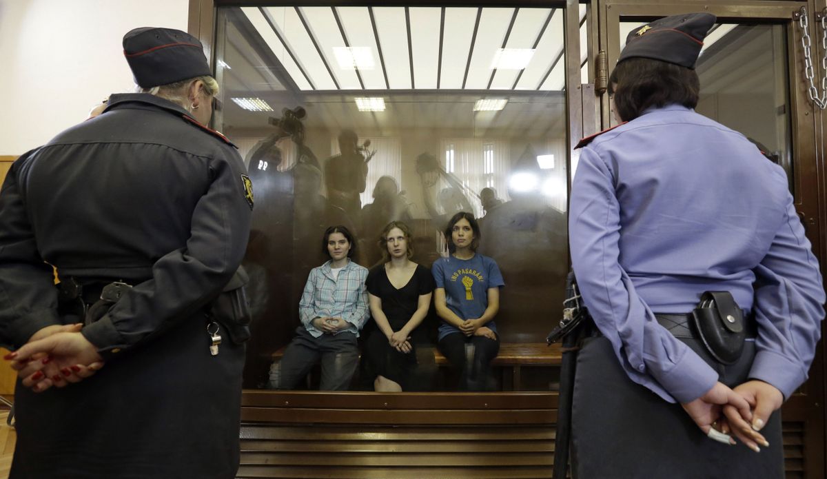 Feminist punk group Pussy Riot members, from left, Yekaterina Samutsevich, Maria Alekhina and Nadezhda Tolokonnikova sit in a glass cage at a courtroom in Moscow on Friday. (Associated Press)