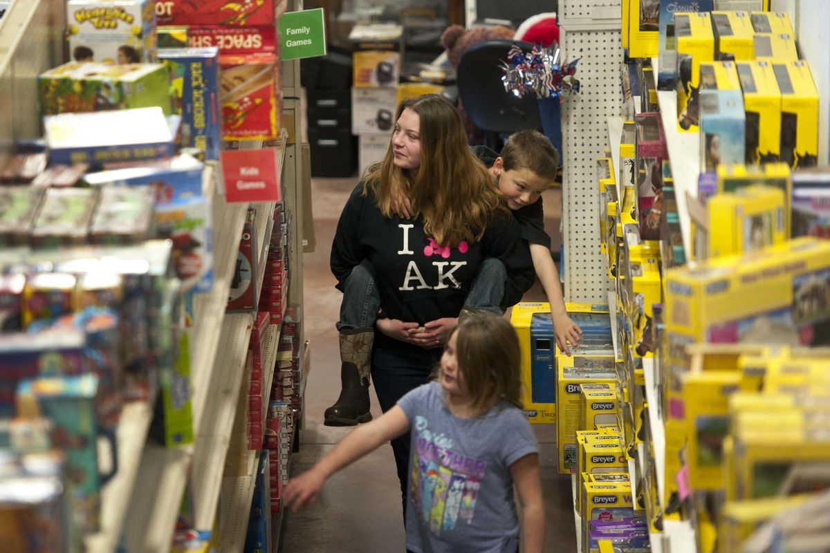 Savannah Baker carries her little brother Hunter McCutcheon, 7, and his twin sister Laycie through White Elephant in Spokane Valley on Friday, Dec. 21, 2018. The three are from Alaska and are in town visiting their grandparents. Kathy Plonka/THE SPOKESMAN-REVIEW (Kathy Plonka / The Spokesman-Review)
