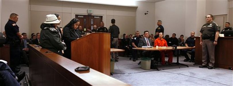 Green River Killer Gary Ridgway, seated at right in orange jumpsuit, listens as family members of Rebecca 