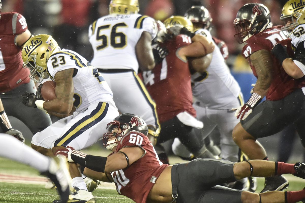 UCLA Bruins running back Nate Starks (23) is brought down by Washington State Cougars defensive lineman Hercules Mata