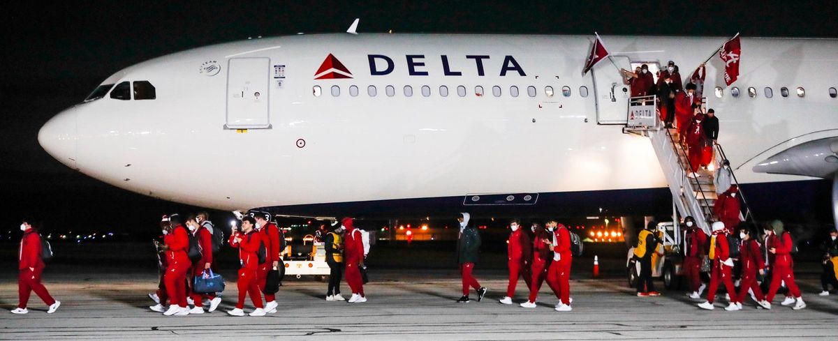 The Alabama team disembarks from a plane Friday, Jan. 7, 2022, at Indianapolis International Airport in Indianapolis. Alabama is scheduled to play Georgia on Monday in the College Football Playoff championship game.  (Michelle Pemberton)