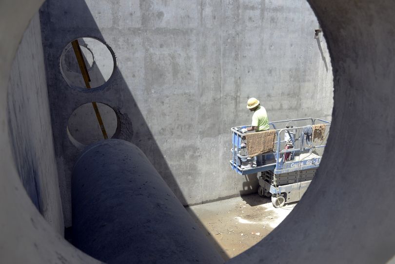 A workman stands inside one of the giant tanks being built at the Coeur d’Alene water treatment facility. (Jesse Tinsley)
