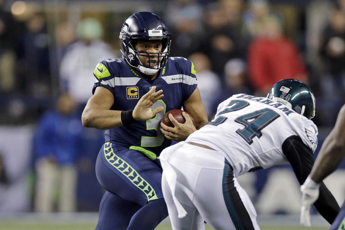 Seattle Seahawks quarterback Russell Wilson, left, scrambles as Philadelphia Eagles