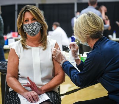 Spokane Mayor Nadine Woodward receives a COVID-19 vaccination from Providence Health Care Chief Operation Officer Peg Currie on April 22 at the Gonzaga University Martin Centre Field House.  (Dan Pelle/THESPOKESMAN-REVIEW)