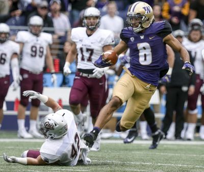 Washington’s Dante Pettis returns a punt for a 67-yard touchdown as Montana’s Josh Buss  falls to the turf during  last Saturday’s game in Seattle. (Kevin Clark / AP)