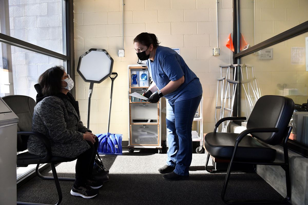 Colville Tribe member Michelle Thomas, left, receives a Covid screening from Medical Support Assistant Deb Stanczak before Thomas received her second dose of the Covid 19 vaccine on Wednesday, February 17, 2021, at Colville Tribes Indian Health in Nespelem, Wash.  (Tyler Tjomsland/The Spokesman-Review)