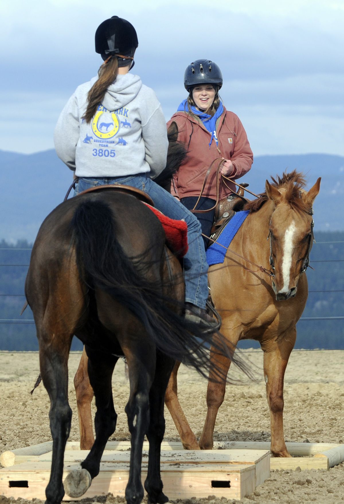 Mead High School students Kami Kanan, 18, left, and Coryelle Scott, 16, talk while practicing on a trail-riding course April 27 at coach Terry Ziegler’s home. (Jesse Tinsley / The Spokesman-Review)