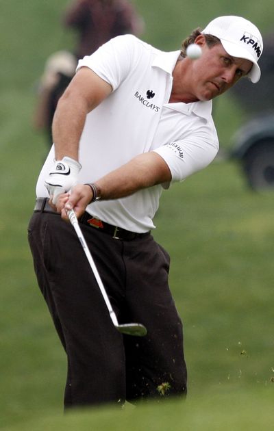 Phil Mickelson hits onto the 18th green during the third round.  (Associated Press / The Spokesman-Review)