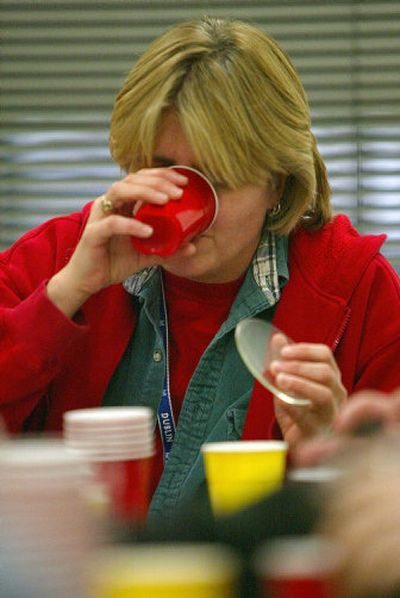 
Water taste expert Stacia Thomas sips a sample of water Dec. 29 in Seattle. Seattle Public Utilities employees were conducting a taste test on 13 samples of water from around the state at the water-testing facility. 
 (Associated Press / The Spokesman-Review)