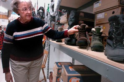 
Lois Huber sells boots at the Army-Navy Store in Coeur d'Alene, including the women's styles shown here. The store sells so many boots it seems they're either putting them out or ringing them up, Huber said.
 (Jesse Tinsley / The Spokesman-Review)