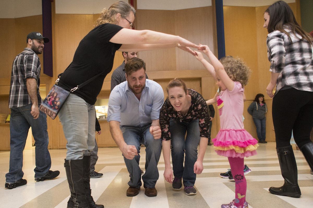 During a Contra Dance, Dan Burger and Liz Oey move through an arch made by Catherine Donnelly and her daughter Lilly, age 4., Friday, Feb 5, 2016. Once a month a family dance night for all ages held at  St. John