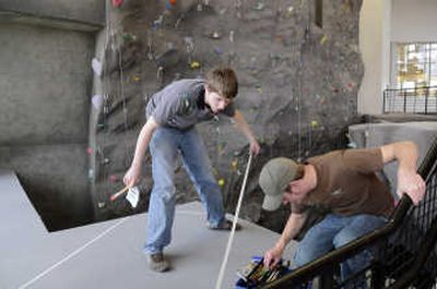 
Students Ryan Desmond and Brandon Jones prepare to paint a sign near the climbing wall at the new EWU Recreation Center  in Cheney. 
 (Dan Pelle / The Spokesman-Review)