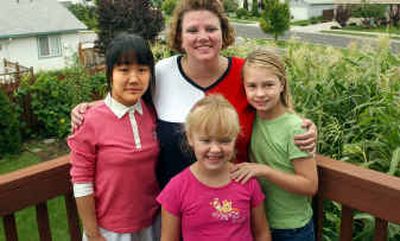 
Barbara Brinton, of Post Falls, shown with her two daughters Elisa, 10, right, and Erika, 7, front, is the local program coordinator for the foreign exchange program PEACE. The Brinton family is temporarily hosting 15-year-old Eun Jin, left, of Korea, until Barbara finds a host family for her for the school year.
 (Kathy Plonka / The Spokesman-Review)