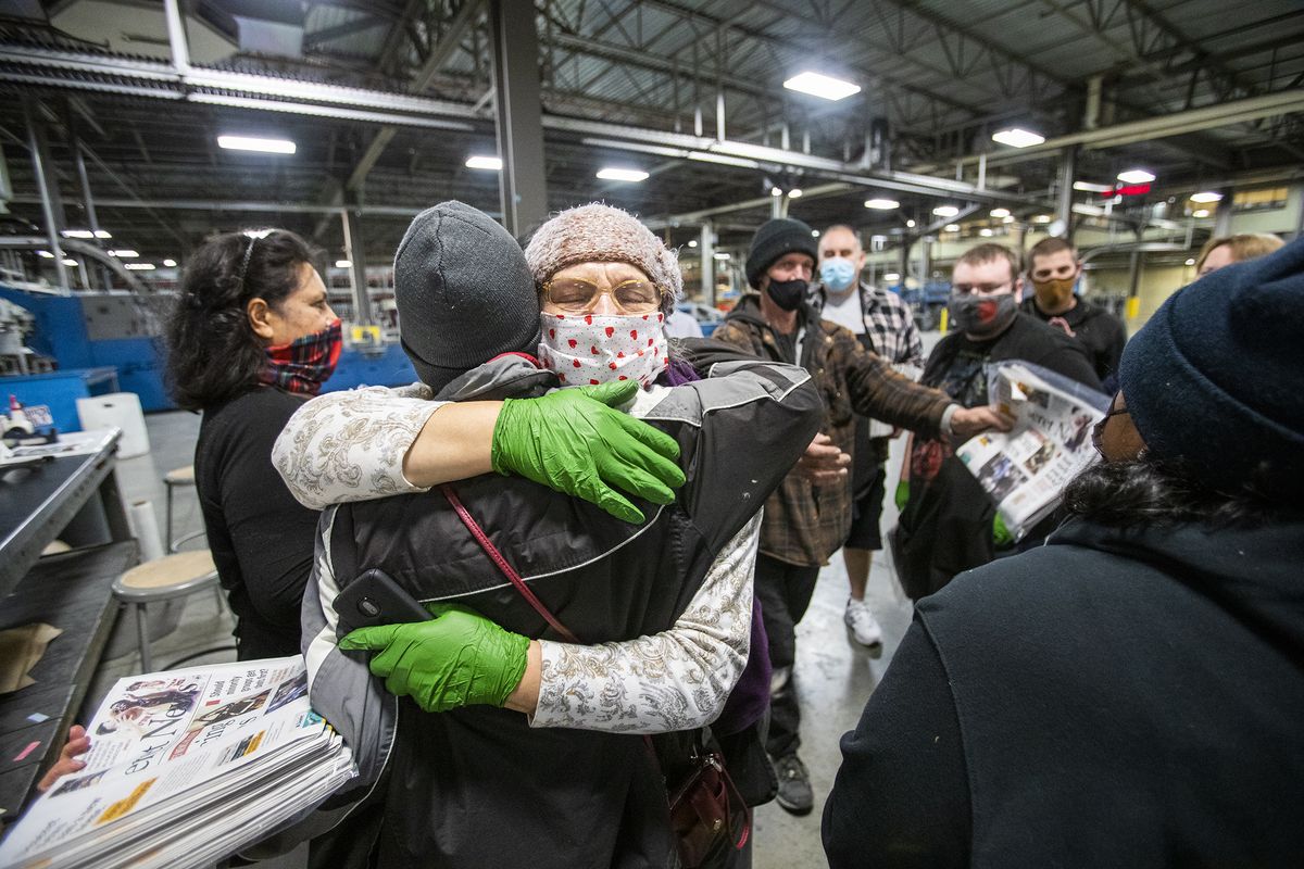 Employees talk and hug each other after the last daily edition of the Deseret News was printed at the MediaOne building in West Valley City, Utah, on Wednesday, Dec. 30, 2020. Both of Salt Lake City