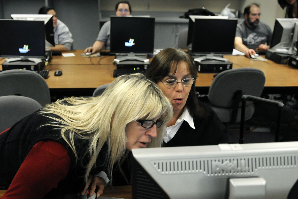 Linda Schultz, left, tries to help Lois DeBates figure out a computer program on Tuesday during the Community Colleges of Spokane Institute of Extended Learning’s College Prep course. Schultz has been a bartender and is planning for a career in health care. (Dan Pelle)