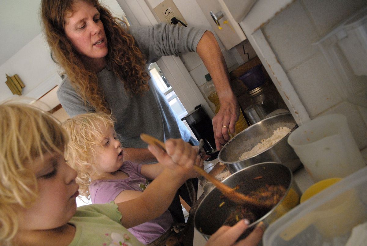 Phinney helps her daughters, Madeleine and Heidi Williams, prepare healthy muffins from their Spokane kitchen last week.  (Photos by Brian Plonka / The Spokesman-Review)