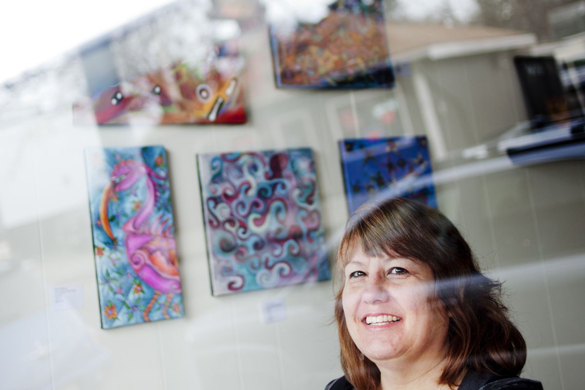 Artist Ellen Paulson poses for a photo Feb. 5 in the Blue Door Theatre on Garland Avenue, where her work is being shown. Paulson creates colorful acrylic paintings with the addition of bold lines in ink. (Tyler Tjomsland)