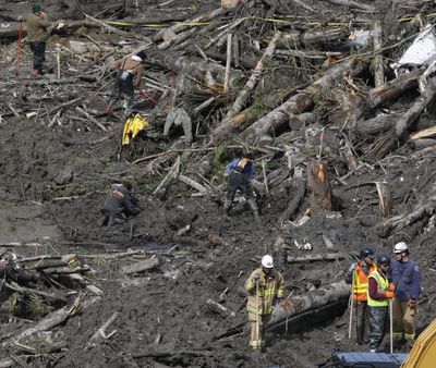 Workers and volunteers search for articles and belongings at the scene of the deadly March 22 mudslide, Monday, March 31, 2014, in Oso, Wash. The number of confirmed dead has reached 24. More than two dozen people remain missing, authorities have said. (Sofia Jaramillo / Pool The Herald)