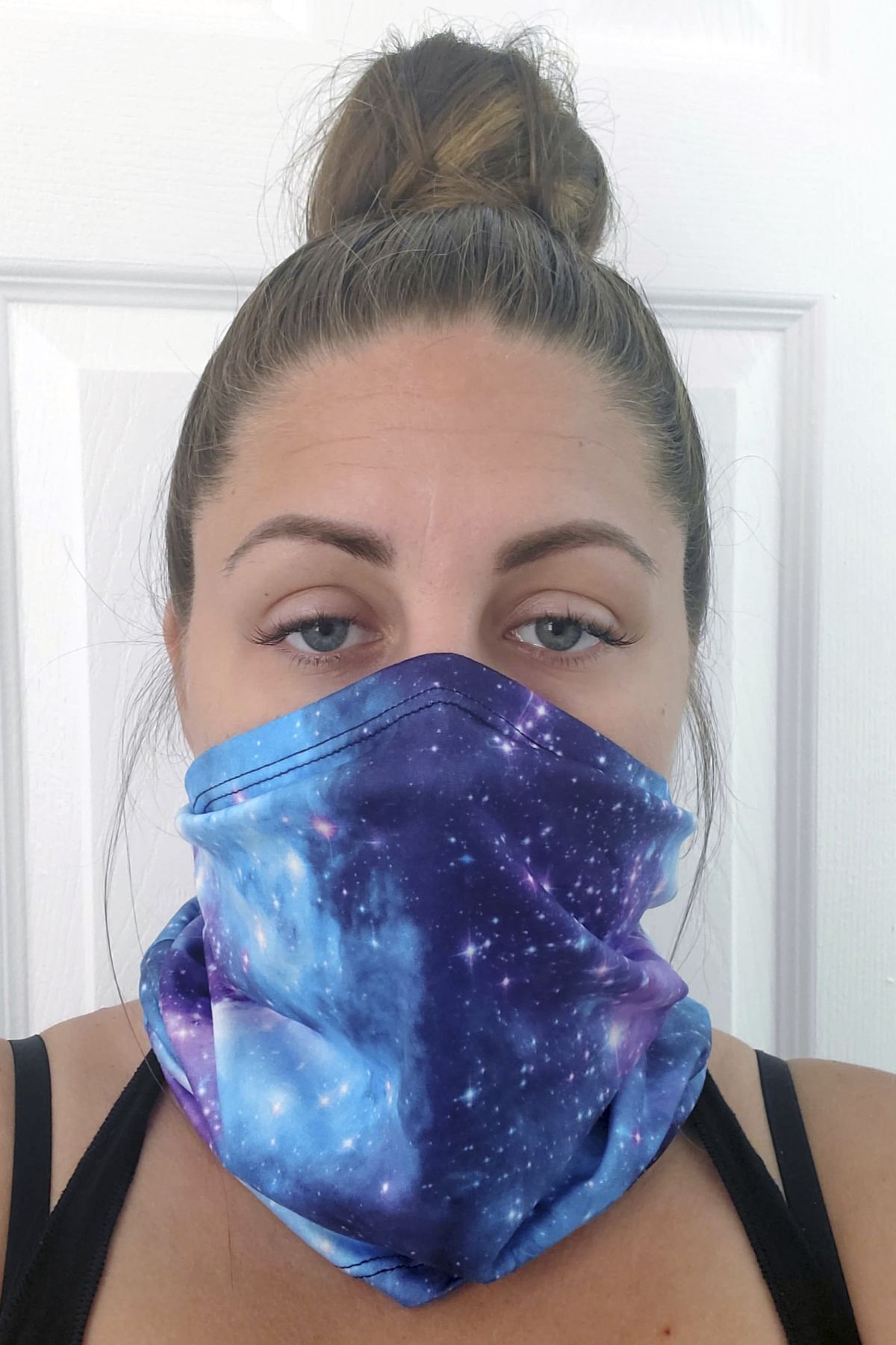 This June 23, 2020 photo provided by Kristen Kowall, 32, of Clearwater, Fla., shows her wearing a mask. In Florida, where many restaurants and bars reopened in early May, Kowall dined out with her fiance in early June. Like others in the restaurant, she didn’t wear a mask. Later she tested positive for COVID-19. “I just feel really groggy and tired. It hurts to walk. Especially my ankles and knees, it feels like my bones are going to fall apart,” she said. “I definitely would advise people from going out. It’s not worth it.”  (Kristen Kowall)