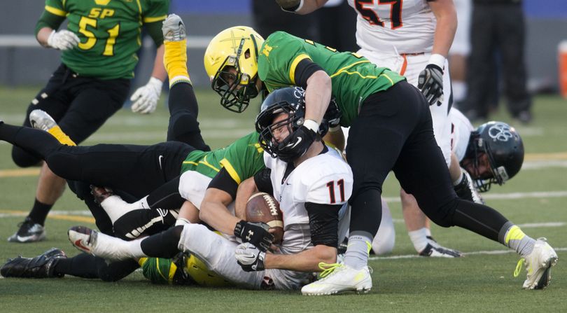 Lewis and Clark's Coleton Fitzgerald (11) is torqued to the groundby the Shadle defense, Kyle Kinney, above, Alec Harmon, behind, and Quentin Wilson, below, during the LC-Shadle Park matchup Friday, Nov. 1, 2013 at Joe Albi Stadium. (Jesse Tinsley / The Spokesman-Review)