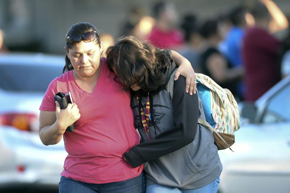 A parent picks up her daughter at Slauson Middle School that was on lockdown as Azusa police and other agencies respond to a shooting near Fourth Street and Orange Avenue in Azusa, Calif. on Tuesday, Nov. 8, 2016. The shooting took place near a polling site. Azusa police say arriving officers found multiple victims, came under fire and returned fire themselves. No officers were injured, and no arrests have been made. (Keith Durflinger / AP)