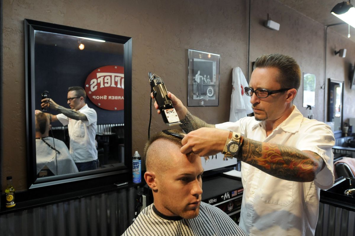 Chris Banka works on the mohawk of Davis Richards Aug. 5 at Porter’s Barber Shop in the Garland District. Banka, Chris Griffith and owner Blaine Burrell run a shop that is a modern twist on the traditional men’s barbershop.  (JESSE TINSLEY PHOTOS / The Spokesman-Review)