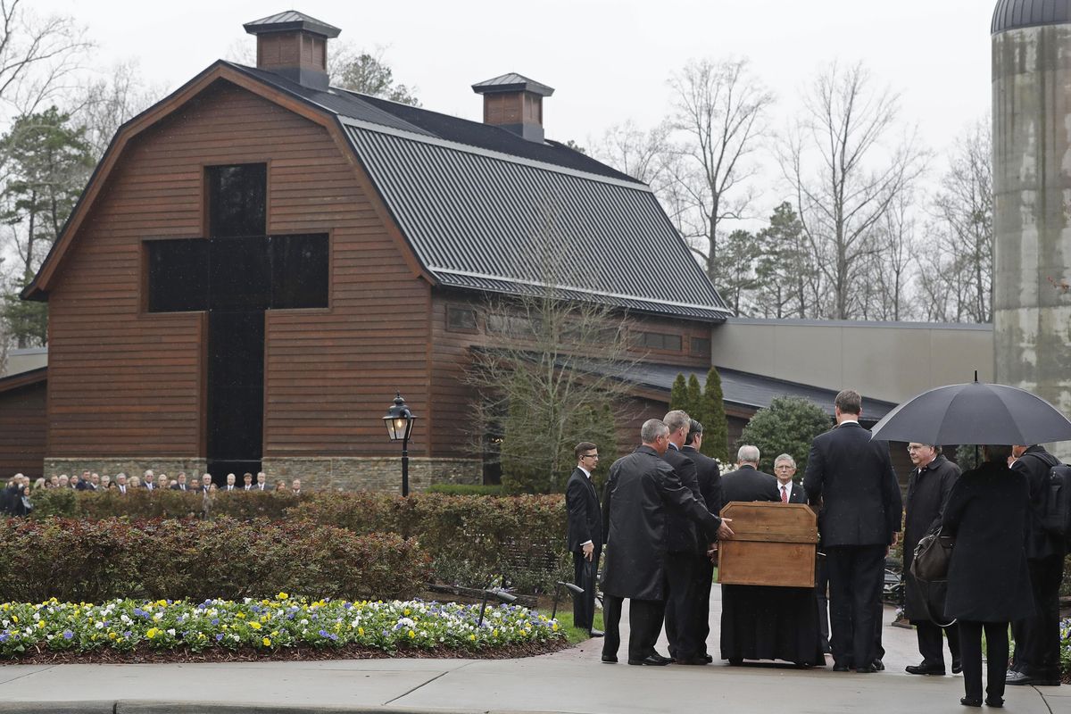 Pallbearers carry the casket of the Rev. Billy Graham past family members as it returns to the Billy Graham Library in Charlotte, N.C., Thursday, March 1, 2018. (Chuck Burton / Associated Press)