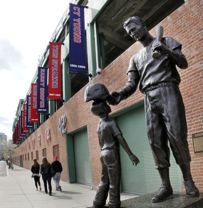 Pedestrians walk past a statue of former Boston Red Sox player Ted Williams outside Fenway Park in Boston Monday, April 9, 2012.  (Elise Amendola / Associated Press)