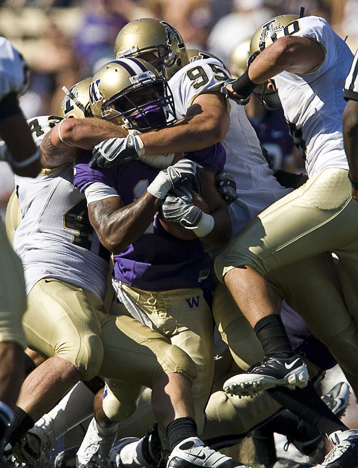 Idaho linebacker Paul Senescall, left, and defensive end Aaron Lavarias (95) tackle UW’s Curtis Shaw in second half. (AP / The Spokesman-Review)