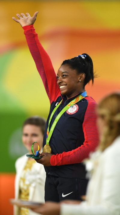 U.S. gymnast Simone Biles waves to the crowd after receiving her gold medal in the all-around competition on Thursday. (Mark Reis / Tribune News Services)