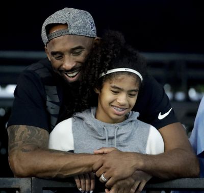 In this July 26, 2018, file photo former Los Angeles Laker Kobe Bryant and his daughter Gianna watch during the U.S. national championships swimming meet in Irvine, Calif. Federal investigators say wreckage from the helicopter that crashed last month and killed Bryant, his daughter and seven others did not show any outward evidence of engine failure, the National Transportation Safety Board said Friday, Feb. 7, 2020. (Chris Carlson / Associated Press)