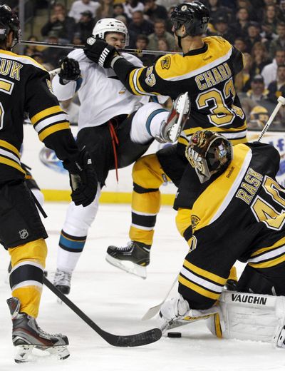 Bruins defenseman Zdeno Chara, right, knocks San Jose rookie Tomas Hertl to the ice as Boston goalie Tuukka Rask defends. (Associated Press)