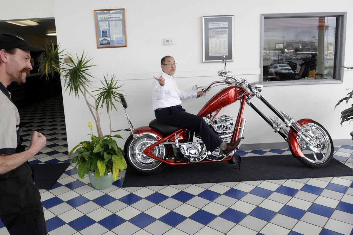 Spokane Auto Center owner Jay Lee (atop the 2008 Big Dog chopper) credits Greg Freter, left, for the custom work on the motorcycle. Lee, the former owner of Spokane Chrysler, will now sell pre-owned vehicles such as cars, RVs, motorcycles and boats at the same location, 6818 E. Sprague in Spokane Valley. (Dan Pelle)